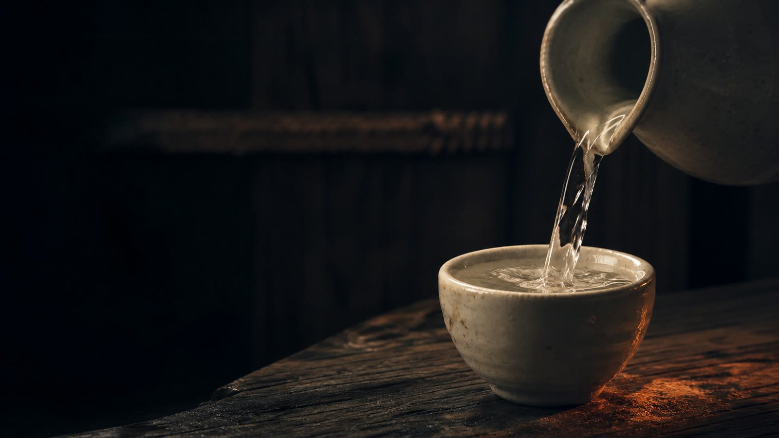 Sake being poured into a ceramic cup